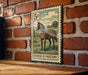 A vintage-style metal stamp depicting a horse in a pastoral setting, mounted on a brick wall.