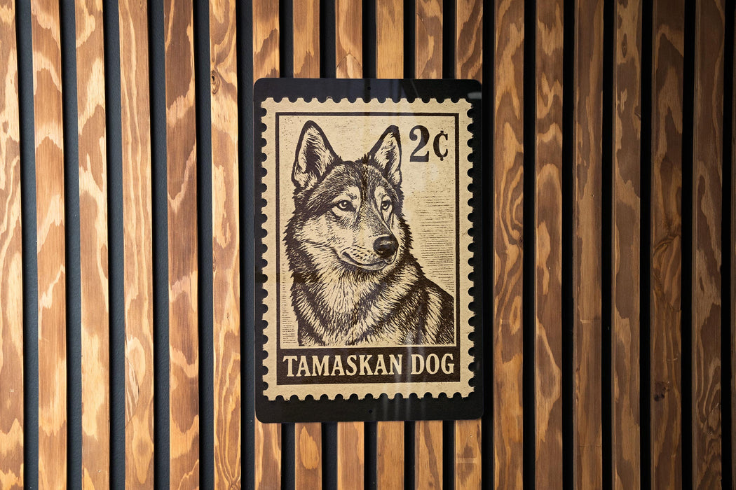 A postage stamp featuring a close-up of a Tamaskan dog, which is a type of wolf dog.