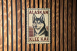 A metal sign with a dog illustration and text is mounted on a wooden wall.