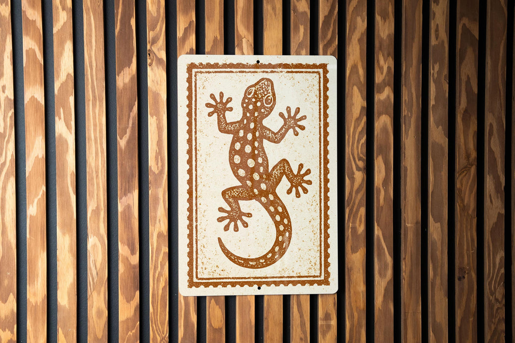 a wooden wall with a rectangular sign featuring a stylized illustration of a lizard.
