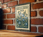 A metal sign with a floral design hangs on a brick wall, featuring the text "BELFLOWER BED" and a depiction of blue bell-shaped flowers.