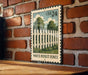 A white picket fence is depicted on a wooden surface, with a brick wall in the background.