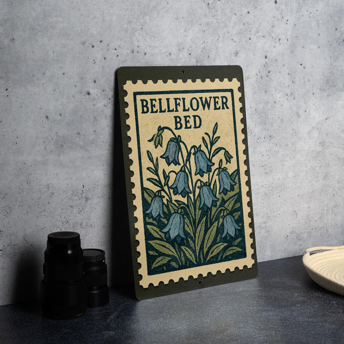 A framed illustration of blue bell flowers on a green background, with the text "BELFLOWER BED" printed on it.