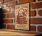 A vintage-style sign with the text "Berry Picking Basket" is displayed on a brick wall, featuring a basket filled with berries.