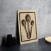 a beige sign with a black illustration of three spoons, placed on a dark surface next to a stack of black containers.