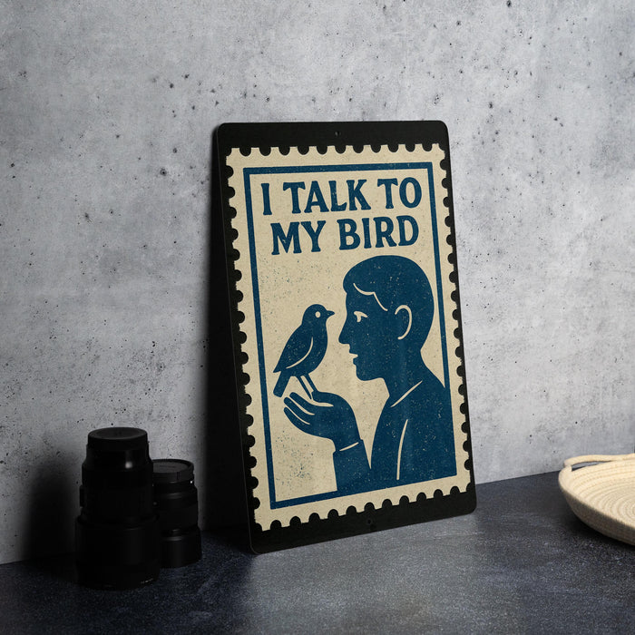 a framed sign with a blue and white design depicting a man holding a bird, accompanied by the text "I TALK TO MY BIRD".
