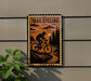 A metal sign with a silhouette of a person riding a bicycle on a trail, surrounded by trees and a cloudy sky.