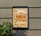 a sign with an illustration of a hay rake on it, mounted on a wall.