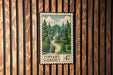 A framed illustration of a garden scene is displayed on a wooden wall, with a postage stamp-like design.