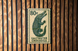 A postage stamp featuring a crocodile, with the text "80c" printed on it.