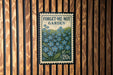 a 20c postage stamp with a floral design, mounted on a wooden wall.