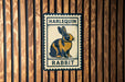 A vintage-style metal sign featuring a rabbit illustration, mounted on a wooden wall.
