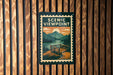 A poster with a scenic view of mountains and a bench is displayed on a wooden wall.