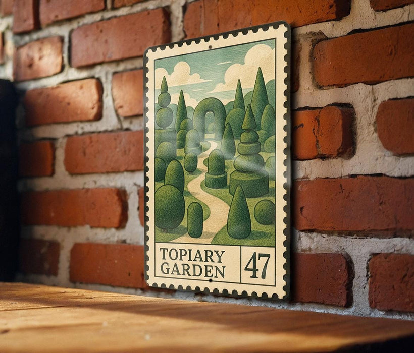 A framed illustration of a topiary garden, featuring a winding path surrounded by lush, meticulously trimmed hedges, is displayed on a brick wall.