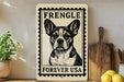 a framed poster of a dog, specifically a French Bulldog, with the text "FREVER USA" printed on it. The poster is displayed on a shelf next to a wooden cutting board and some kitchen utensils.