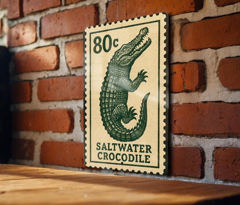 A green and white postage stamp featuring a crocodile is displayed on a brick wall.