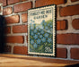 a vintage-style metal sign with a floral design, mounted on a brick wall.