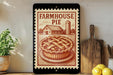 a vintage-style metal sign with a pie illustration, placed on a wooden surface next to kitchen utensils and a potted plant.