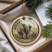 A decorative ornament featuring an elephant is displayed in a box, surrounded by pine branches.