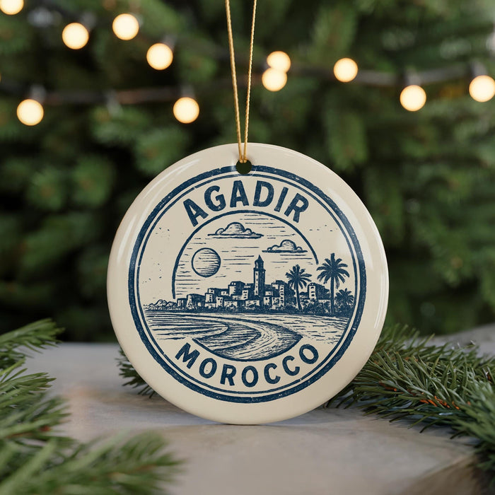 A circular ornament with a graphic design featuring a cityscape and palm trees, with the text "AGADIR MOROCCO" prominently displayed.