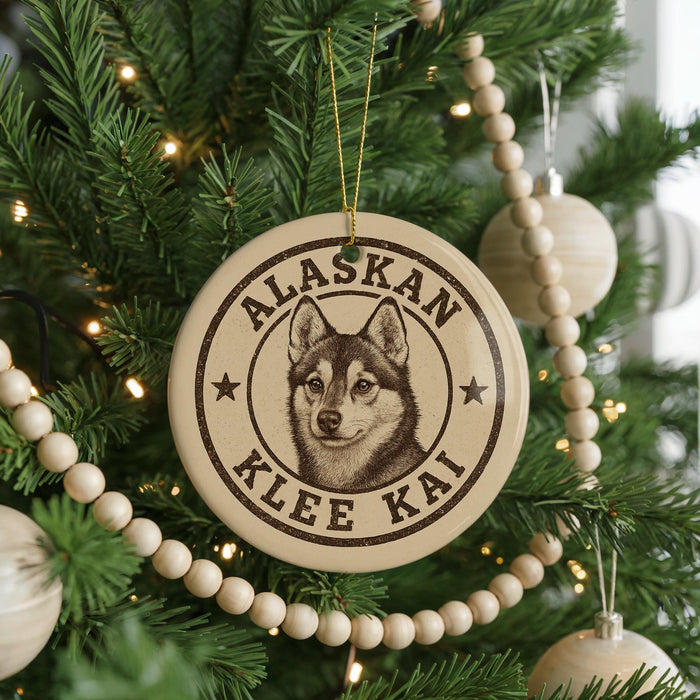 A Christmas tree decorated with ornaments, including a circular ornament with a picture of a husky dog and the text "Alaskan Klee Kai".