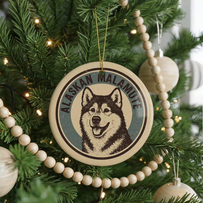 A Christmas tree decorated with ornaments, including a circular ornament featuring a picture of a husky dog and the text "Alaskan Malamute".