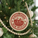 A Christmas tree decorated with ornaments, including a circular ornament with the text "ALBUQUERQUE NEW MEXICO" and a wooden bead decoration.