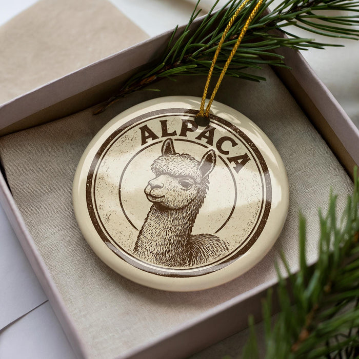A decorative ornament featuring an image of an alpaca, with the word "ALPaca" written around the center of the image.