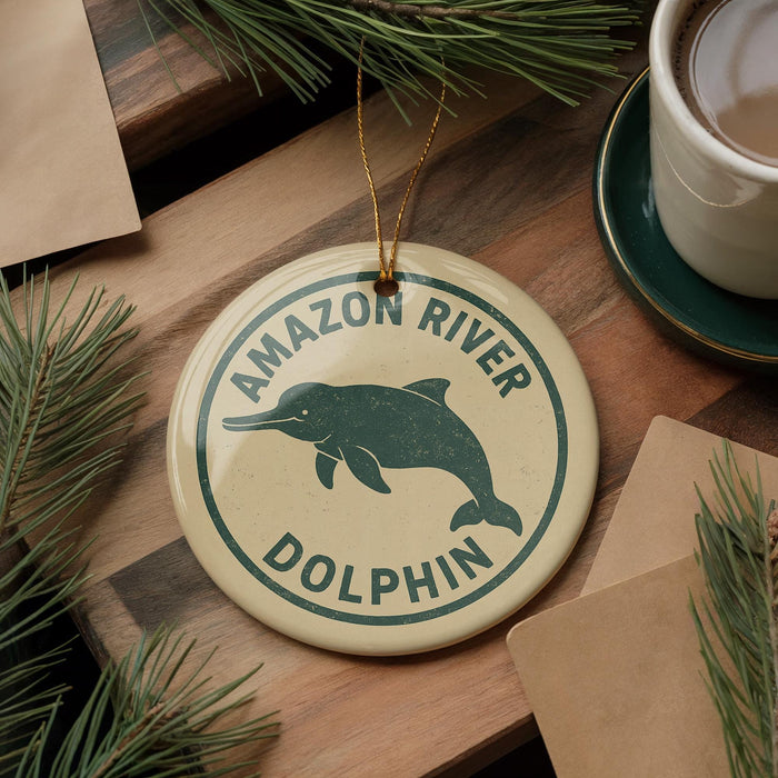 A round ornament with a green dolphin on it, hanging on a wooden surface.