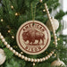 A Christmas tree decorated with ornaments, including a circular ornament with a bison illustration and the text "AMERICAN BISON" on it.