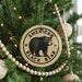 A Christmas tree decorated with ornaments, including a circular ornament with a bear image and the text "AMERICAN BLACK BEAR".