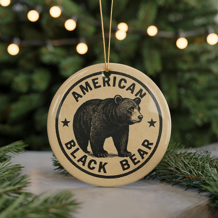 A circular ornament featuring a black bear image and the text "AMERICAN BLACK BEAR" is displayed in front of a blurred Christmas tree.