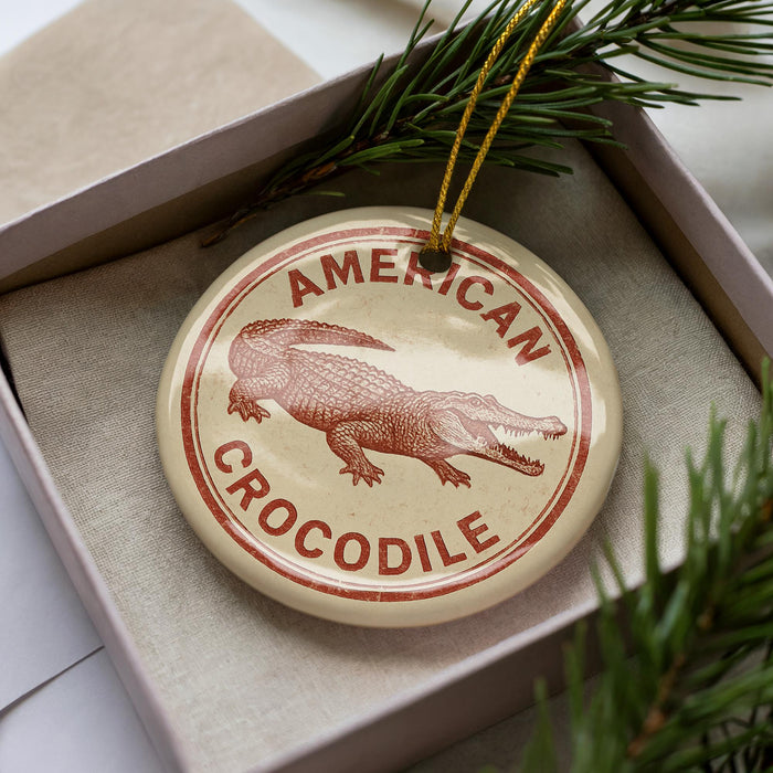 A circular ornament with the text "AMERICAN CROCODILE" printed on it, featuring an illustration of a crocodile.