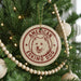 A Christmas tree decorated with ornaments, including a circular ornament with a dog's face and the text "AMERICAN ESKIMO DOG" printed on it.