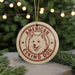 A circular ornament featuring an image of an Eskimo dog, with the text "AMERICAN ESKIMO DOG" printed on it.