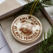 A circular ornament with a picture of a pit bull terrier dog and the text "AMERICAN PIT BULL TERRIER" printed on it.