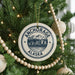 A Christmas tree decorated with ornaments, including a circular ornament with the text "ANCHORAGE ALASKA" and a mountain landscape.