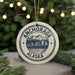 A circular ornament with the text "ANCHORAGE ALASKA" and a graphic of a mountain range, hanging from a string.