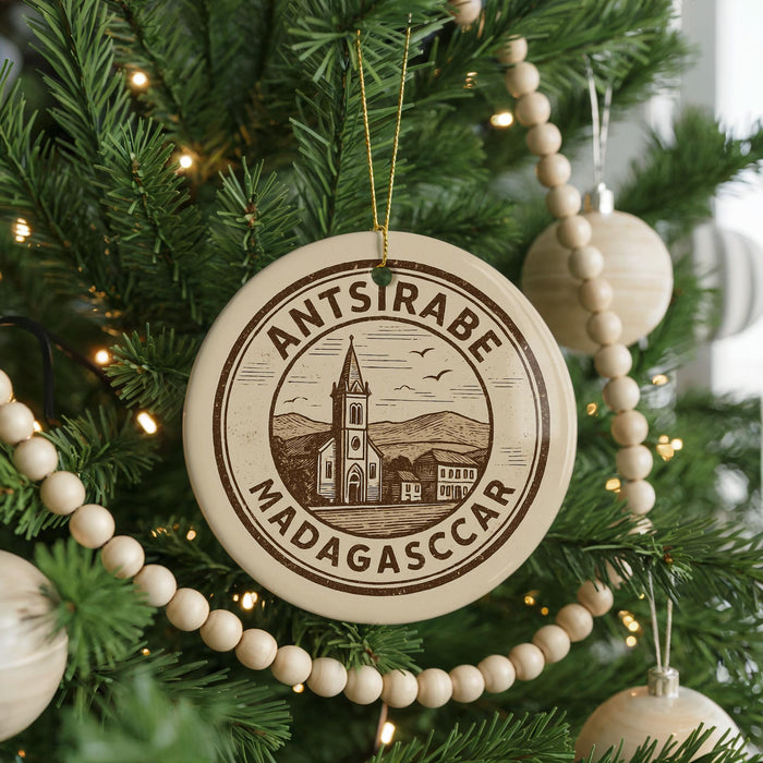 A Christmas tree decorated with ornaments, including a circular ornament with the text "ANTSTRÆBÉ MADAGASCAR" and a church illustration.