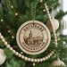 A Christmas tree decorated with ornaments, including a circular ornament with the text "ANTSTRÆBÉ MADAGASCAR" and a church illustration.