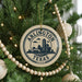 A circular ornament on a Christmas tree, featuring the text "ARLINGTON TEXAS U.S.A." and a graphic of a city skyline.