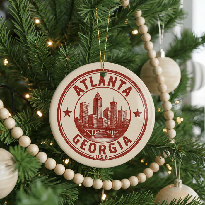 A Christmas tree decorated with ornaments, including a circular ornament with the text "ATLANTA GEORGIA USA" and a wooden bead decoration.