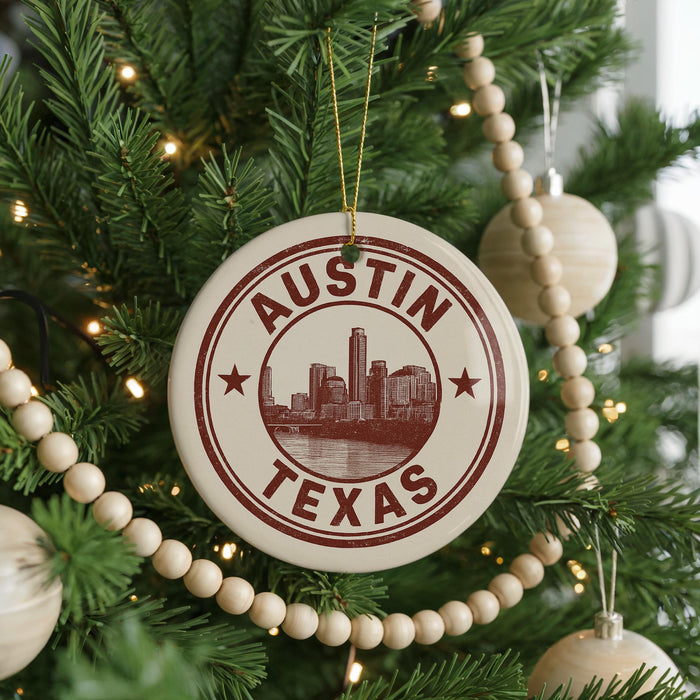 A Christmas tree decorated with ornaments, including a circular ornament with the text "AUSTIN TEXAS" and a cityscape image.