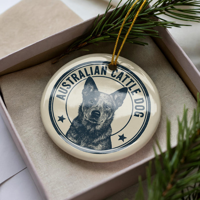 A circular ornament featuring a black and white image of a dog, with the text "AUSTRALIAN CATTLE DOG" printed on it.