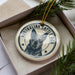 A circular ornament featuring a black and white image of a dog, with the text "AUSTRALIAN CATTLE DOG" printed on it.