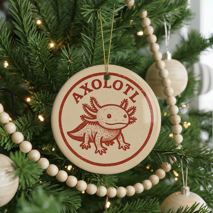 A Christmas tree decorated with ornaments, including a circular ornament with a red and white design featuring a cartoon axolotl.