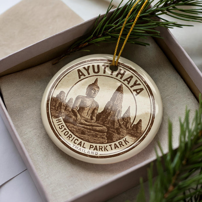 A circular ornament with a Buddha image and the text "AYUTHAYA HISTORICAL PARKTARK THAILAND" is displayed in a box with pine branches.
