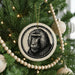 A Christmas tree decorated with ornaments, including a circular ornament featuring a monkey's face.