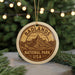 A circular ornament with the text "BADLANDS NATIONAL PARK USA" printed on it, featuring a mountain landscape design.