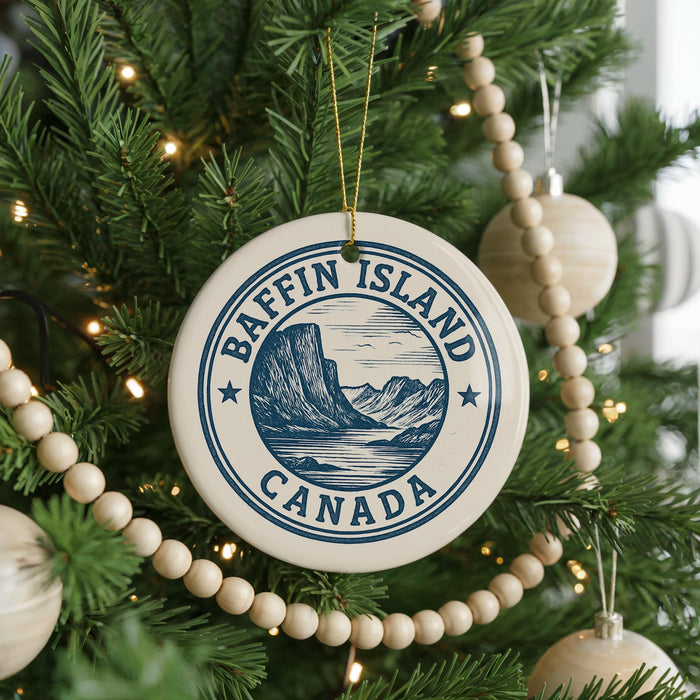 A Christmas tree decorated with ornaments, including a circular ornament with the text "Baffin Island Canada" and a mountain illustration.